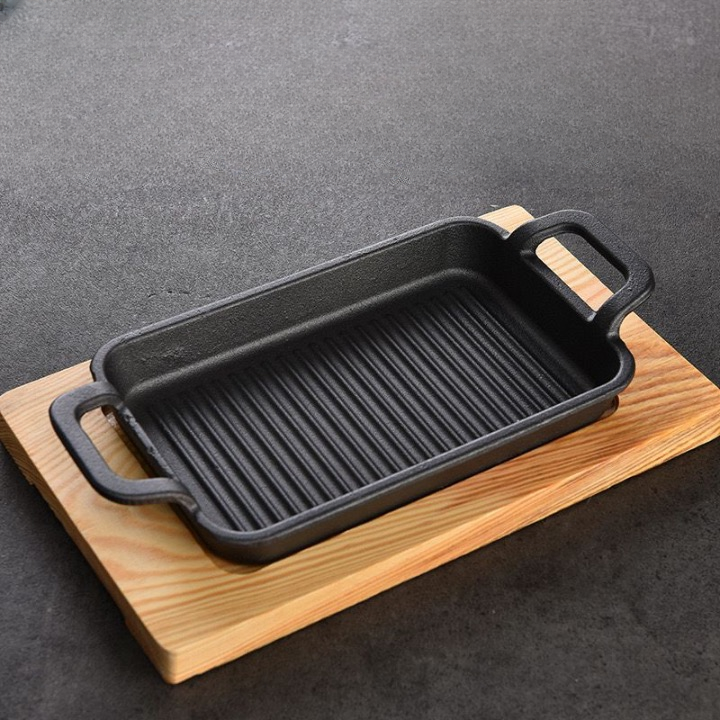 مقلاة  جريل من الحديد الزهر  بيد  مع قاعدة خشب علي شكل مستطيل غير لاصقه