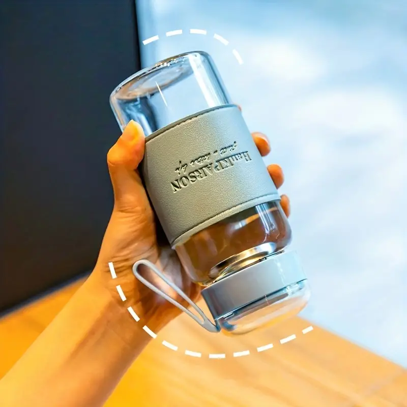 زجاجة مياه 340 ملي بمصفاه وغطاء محكم الغلق ويد لسهولة الحمل من الزجاج بكفر جلد