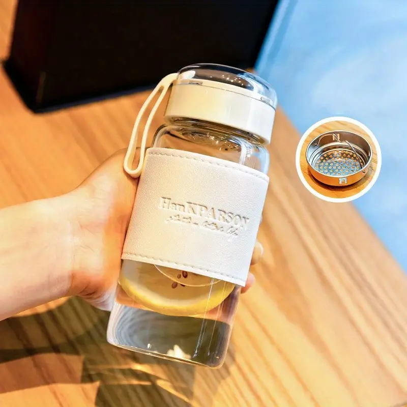 زجاجة مياه 340 ملي بمصفاه وغطاء محكم الغلق ويد لسهولة الحمل من الزجاج بكفر جلد