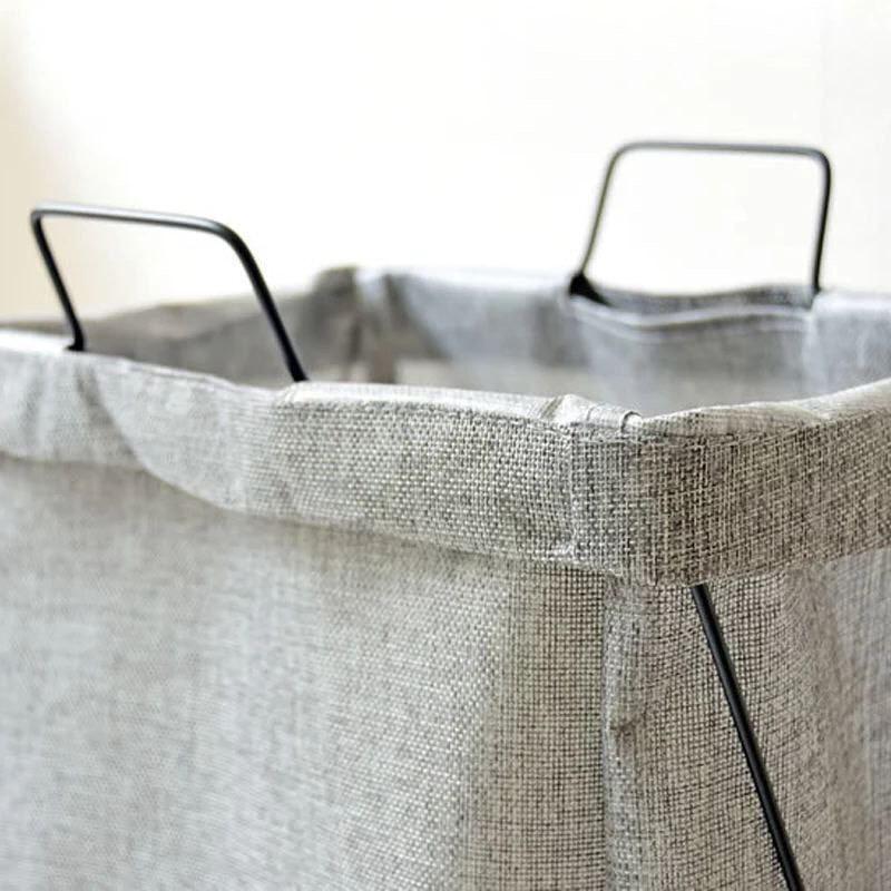 سلة غسيل بكسوة كتان واستاند معدن قابل للطي بيد لسهولة الحمل