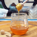 برطمان زجاج للعسل مع غطاء و معلقة خشب شكل خلية نحل 250 مللي