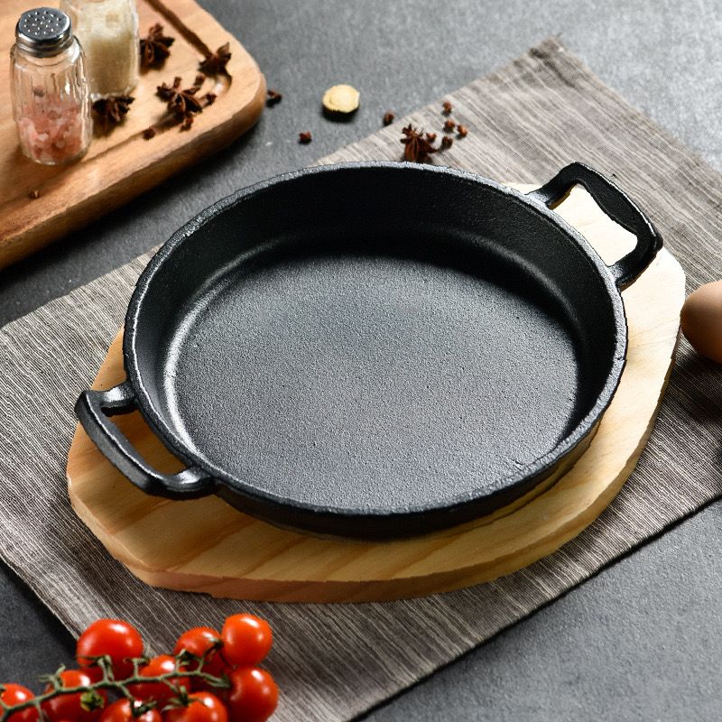طاسة حديد زهر غير لاصق بيد وقاعدة خشبية لتسوية وتقديم الطعام علي السفرة وقت العزومات بشكل شيك