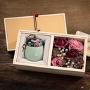 صندوق خشبي مزين بالورود مع شمعة معطرة داخل وعاء سيراميك لإضفاء أجواء هادئة ومناسب كهدية